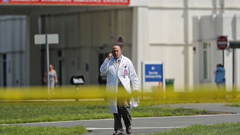 A physician walks out of the emergency entrance to Westchester Medical Center, Wednesday, Aug. 8, 2018, in Valhalla, N.Y. A man shot a female patient and then killed himself at the suburban New York hospital Wednesday, police said.