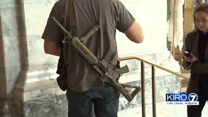 Nick, who declined to share his last name, is pictured in the Washington state Captiol with his semi-automatic rifle. He and others in western Washington want their own state.
