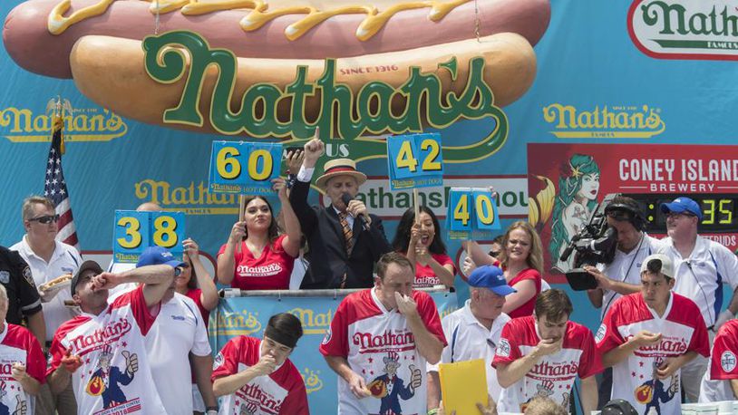 Reigning champion Joey Chestnut eats two hot dogs at a time during the men's competition of the Nathan's Famous Fourth of July hot dog eating contest, Wednesday, July 4, 2018, in New York's Coney Island. The defending champion broke his own world record by eating 74 hot dogs in 10 minutes.
