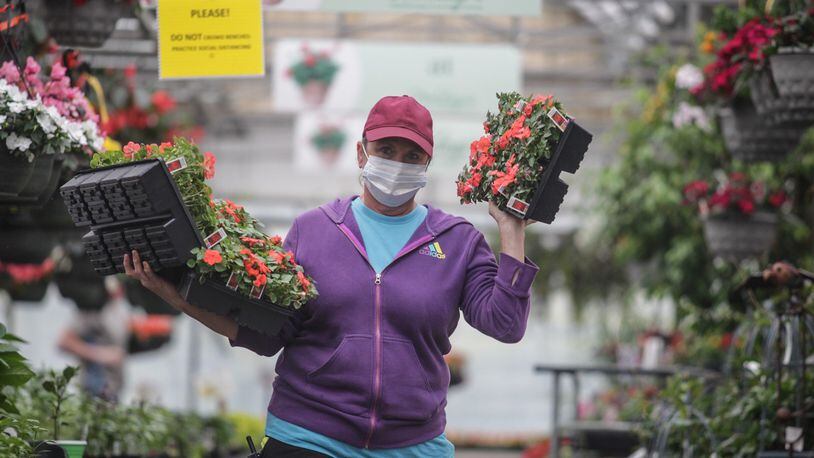 Stockslagers Greenhouse and Garden Center transplanter Heather Rettich moves plants around the garden center Tuesday afternoon. Business has been exceptional for local garden center this Spring. JIM NOELKER/STAFF