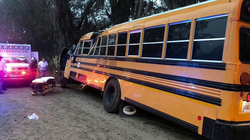 Authorities investigate the scene where a school bus crashed, Tuesday, Dec. 5, 2017, in Gum Branch, Ga. Liberty County Public Safety Director Mike Hodges said more than 20 children were riding the bus when it crashed  into a tree during its morning pick-up route. (AP Photo/Lewis Levine)