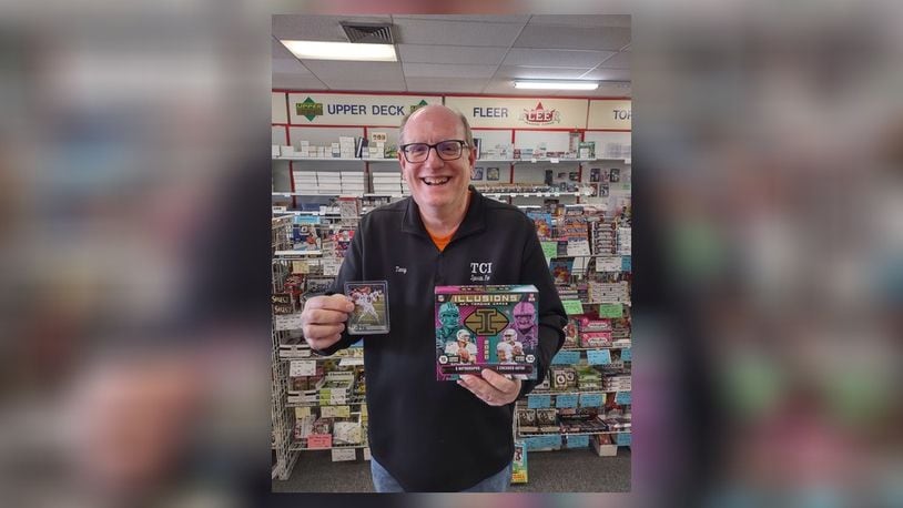 Terry Carter, owner of TCI Sports Fan in Dayton, holds a $1,200 box of 2020 Illusions Football and an unautographed $10 Joe Burrow rookie card from 2020 Panini. SUBMITTED PHOTO