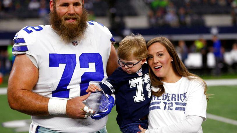 FILE - In this Dec. 24, 2017, file photo, Dallas Cowboys center Travis Frederick (72), and his wife Kaylee, right, pose for a photo as their son Oliver, reaches out to the NFL Man of the Year team nominee award presented to Frederick before an NFL football game against the Seattle Seahawks, in Arlington, Texas. Frederick's revelation that he is battling a rare neurological disorder will reverberate on and off the field for the Dallas Cowboys. They're likely to begin the season without their stalwart at center, and without knowing what will happen with their teammate's recovery. (AP Photo/Ron Jenkins, File)