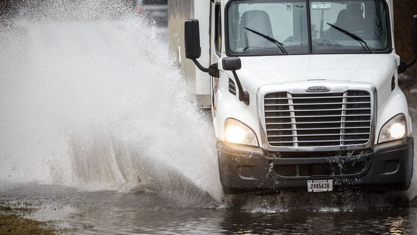 A truck drives through high water caused by heavy rain Tuesday, Feb. 22, 2022, on Nicholas Road in Dayton. MARSHALL GORBY/STAFF