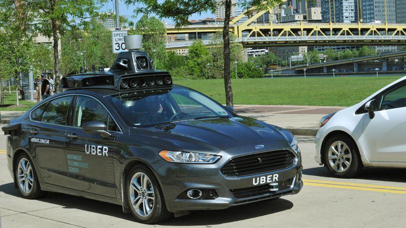 FILE - In this undated file photo provided by Uber, a Ford Fusion hybrid outfitted with radars, laser scanners and high-resolution cameras drives along the streets of Pittsburgh. Uber said Thursday, Aug. 18, 2016, that passengers in Pittsburgh will be able to summon rides in self-driving cars with the touch of a smartphone button in the next several weeks. The high-tech ride-hailing company said that an unspecified number of autonomous Ford Fusions with human backup drivers will pick up passengers just like normal Uber vehicles. Riders will be able to opt in if they want a self-driving car, and rides will be free to those willing to do it, spokesman Matt Kallman said. (Uber via AP, File)