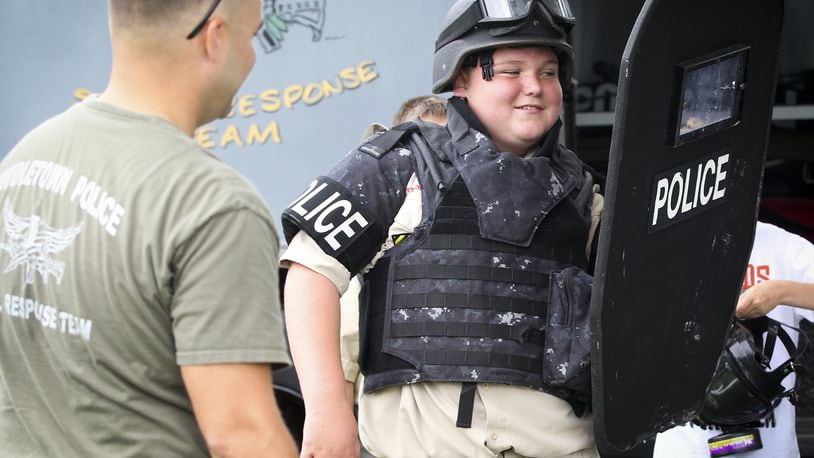 Tobi Wilder, 12, of Middletown, tries on Special Response Team tactical gear with the help of Gary Bender during the 2014 Middletown Division of Police annual National Night Out. GREG LYNCH / STAFF