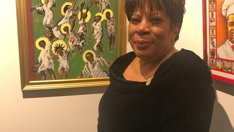 Dayton artist Clarice Moore poses with her painting, Ascension of Souls, which hangs in the Museum of Science+Industry in Chicago. CONTRIBUTED