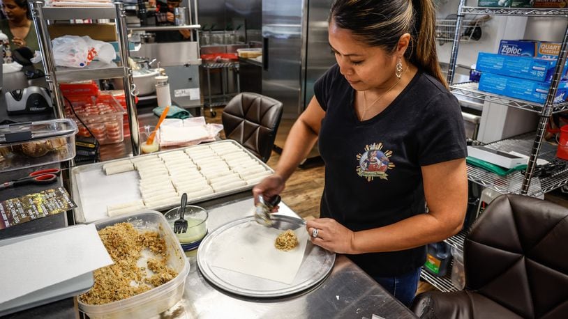 Catherine Roberts, owner of Lumpia Queen makes lumpias which are Filipino spring rolls at her restaurant at West Social Tap and Table. The food hall opened in 2022. JIM NOELKER/STAFF