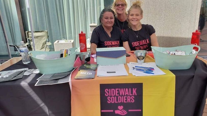 “Sidewalk Soldiers” Resource Table at Courthouse Square. Volunteer Angely Swaney and Board of Directors - Amy Russ and Amanda Thompson.