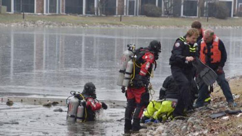 Divers search in a retention pond for a man who dived into the icy waters to save a dog.