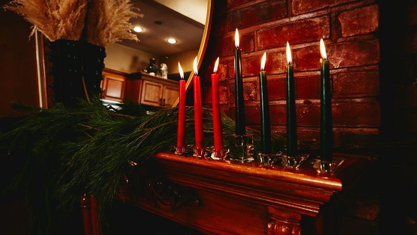 The kinara, or candleholder, on the mantle of Krystal Stark and Kerry Coddett, in New York, Dec. 11, 20020. The seven candles (red, black and green) represent the seven Kwanzaa values. (Timothy Smith/The New York Times)