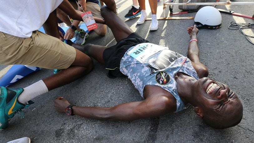 July 04, 2017 Atlanta: Leonard Korir collapses to the street after the finish line winning the 48th running of the AJC Peachtree Road Race with an unofficial time of 28:16 on Tuesday, July 4, 2017, in Atlanta.    Curtis Compton/ccompton@ajc.com