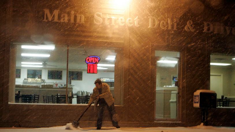 In this file photo f rom 2009, Steve Swank, owner of the Main Street Deli in Springboro, cleans the sidewalk in front of his business as he prepares for the workday. The deli announced on Facebook it will shut its doors on Jan. 30, 2021.