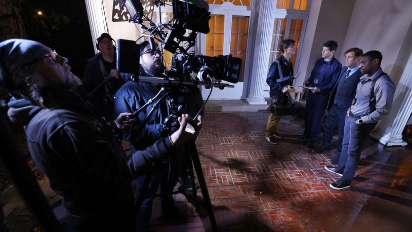 Left to right: Director of Photography Phillip Booth operates the camera and Adam Michael Johnson pulls focus during a scene with actors Mark Schuliger, Greg Lehman, Michael Paré and Wendell Kinney on set of director Lana Read's new film, "Death for Dinner", at the historic home of Helen and Rick Stevens-Gleason in early morning hours Saturday, March 16, 2024 in Middletown. NICK GRAHAM/STAFF