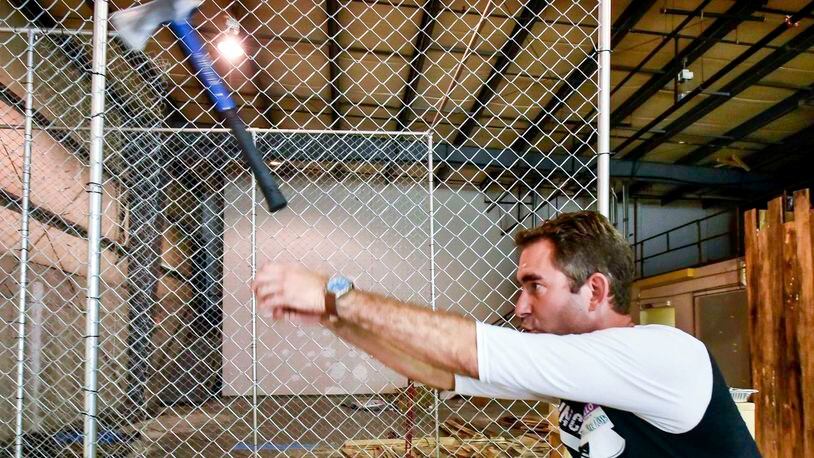 Marty Parker with Cincinnati Axe Throwing demonstrates how to throw an axe at their new location at 4814 Peter Place just off of Ohio 747 in West Chester Township. An entertainment venue that includes Ax throwing is planned for the Fire Blocks District.  NICK GRAHAM/STAFF