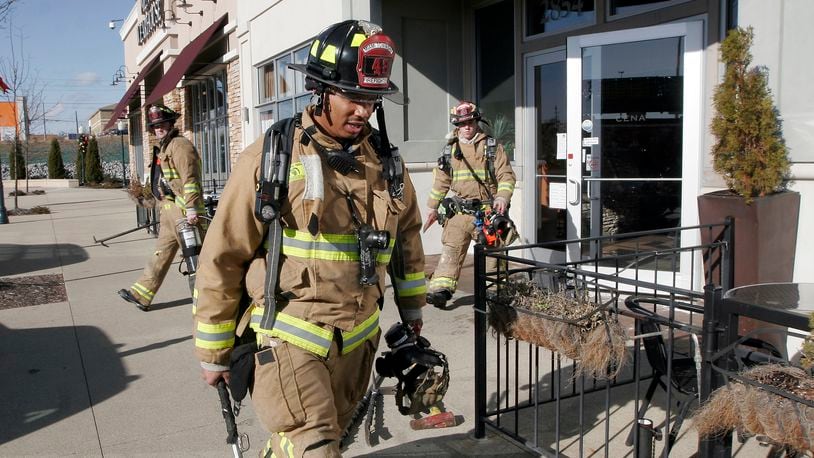 Firefighters respond to a fire in the kitchen of Cena restaurant near the Dayton Mall Saturday, Dec. 26.  Customers and employees at adjacent businesses were evacuated during the fire.