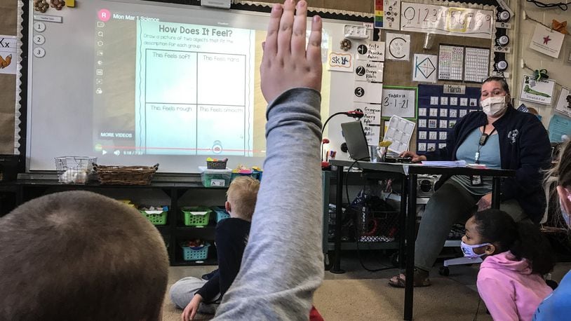 Orchard Park Elementary teacher Cary Forlines answers question from first-graders Tuesday March 2, 2021. The Kettering school opened for in-person learning in late January after months of COVID-19 restrictions.