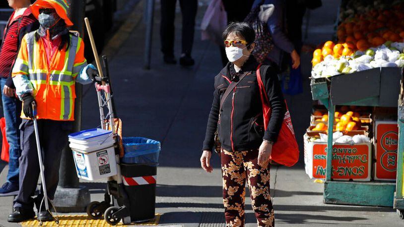 A masked worker and shopper wait for a street signal Friday, Jan. 31, 2020, in the Chinatown district in San Francisco. As China grapples with the growing coronavirus outbreak, Chinese people in California are encountering a cultural disconnect as they brace for a possible spread of the virus in their adopted homeland. (AP Photo/Ben Margot) (Ben Margot/AP)