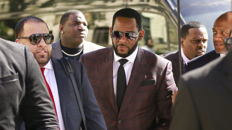 In this June 26, 2019, file photo, R&B singer R. Kelly, center, arrives at the Leighton Criminal Court building for an arraignment on sex-related felonies in Chicago.
