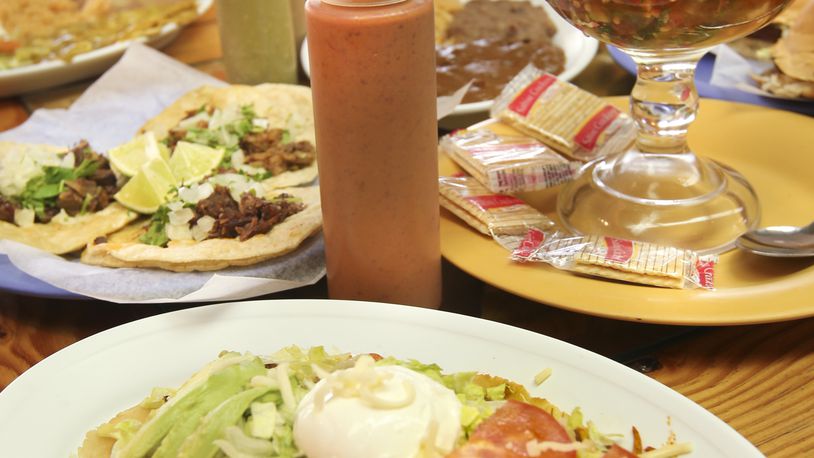 A spread of adventurous food at Taqueria Mixteca mexican restaurant at 1609 E. Third St., Dayton. Foreground shows Huarche, background left are three different meat tacos and on right in glass bowl is Seafood Cocktail.