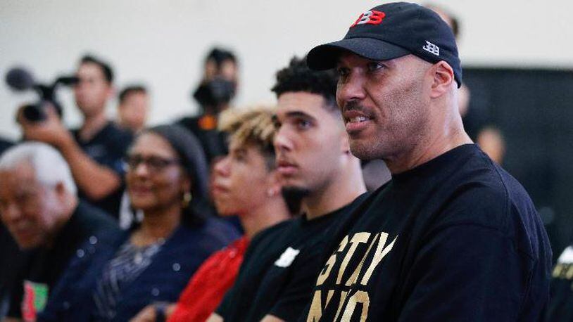 FILE - In this June 23, 2017, file photo, LaVar Ball, right, father of Los Angeles Lakers draft pick Lonzo Ball, listens to his son during the NBA basketball team's news conference in El Segundo, Calif. Ball questioned the extent of President Donald Trumpâs involvement in securing his sonâs release from the custody of Chinese authorities during a combative 20-minute CNN interview on Monday, Nov. 20, 2017. (AP Photo/Jae C. Hong, File)