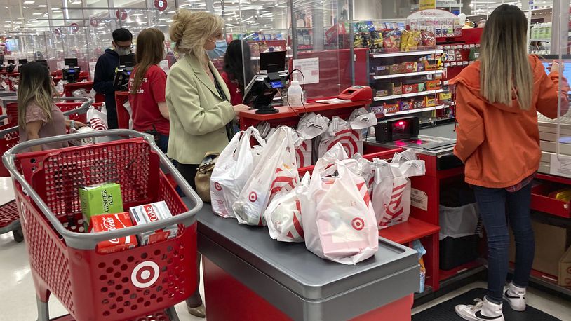FILE - A customer wears a mask as she waits to get a receipt at a register in Target store in Vernon Hills, Ill., Sunday, May 23, 2021.  (AP Photo/Nam Y. Huh, File)